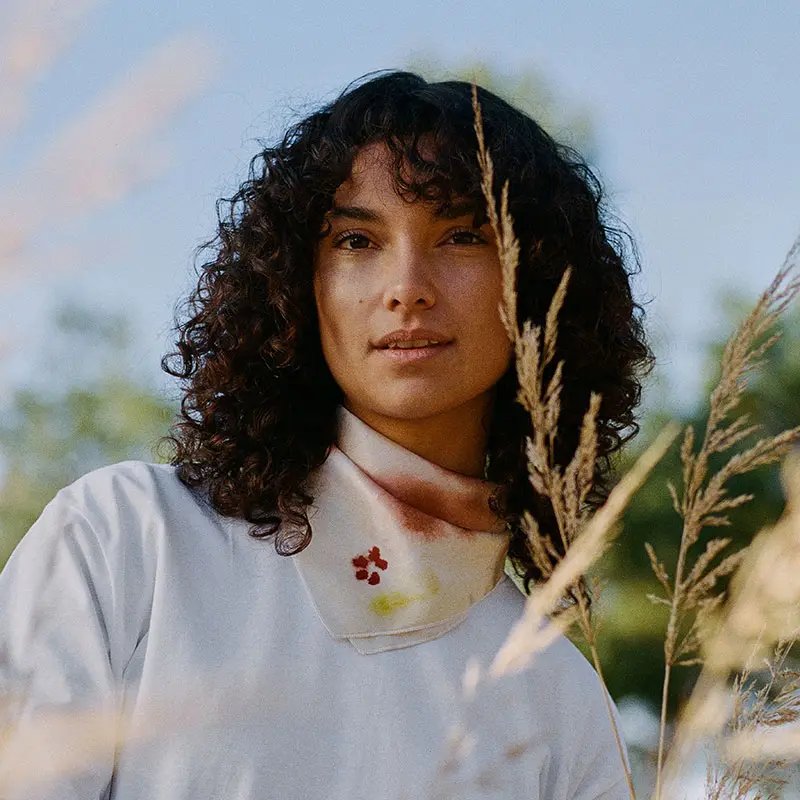Young woman with curly hair in a pampa field