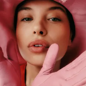 Woman wearing a big pink hat and pink gloves