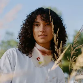 Young woman with curly hair in a pampa field