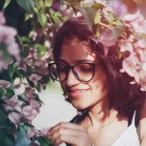 Young woman touching the flower of the Bougainvillea
