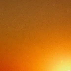 A silhouette of an industrial structure is contrasted against a vibrant sunset, with shades of orange and yellow blending into a warm sky, creating a serene atmosphere.